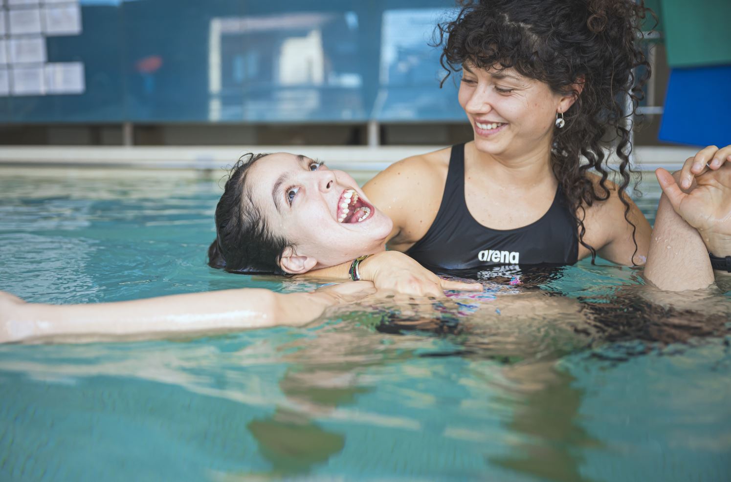 Therapeutin und Maedchen im Schwimmbad bei der Therapie